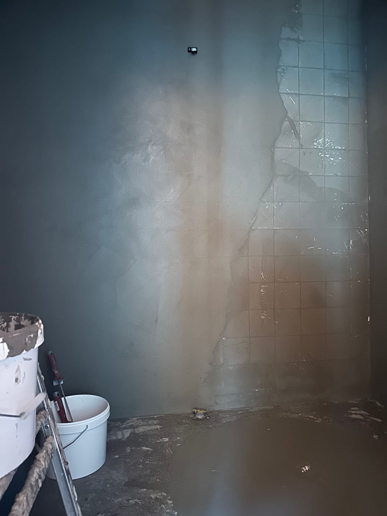 Microcement dras över gammalt kakel, fogarna försvinner lager för lager